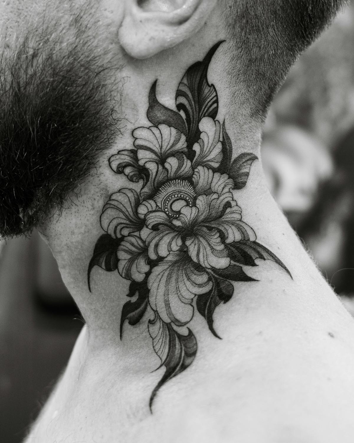 Bold blackwork floral piece on the neck, dense linework, fresh ink.