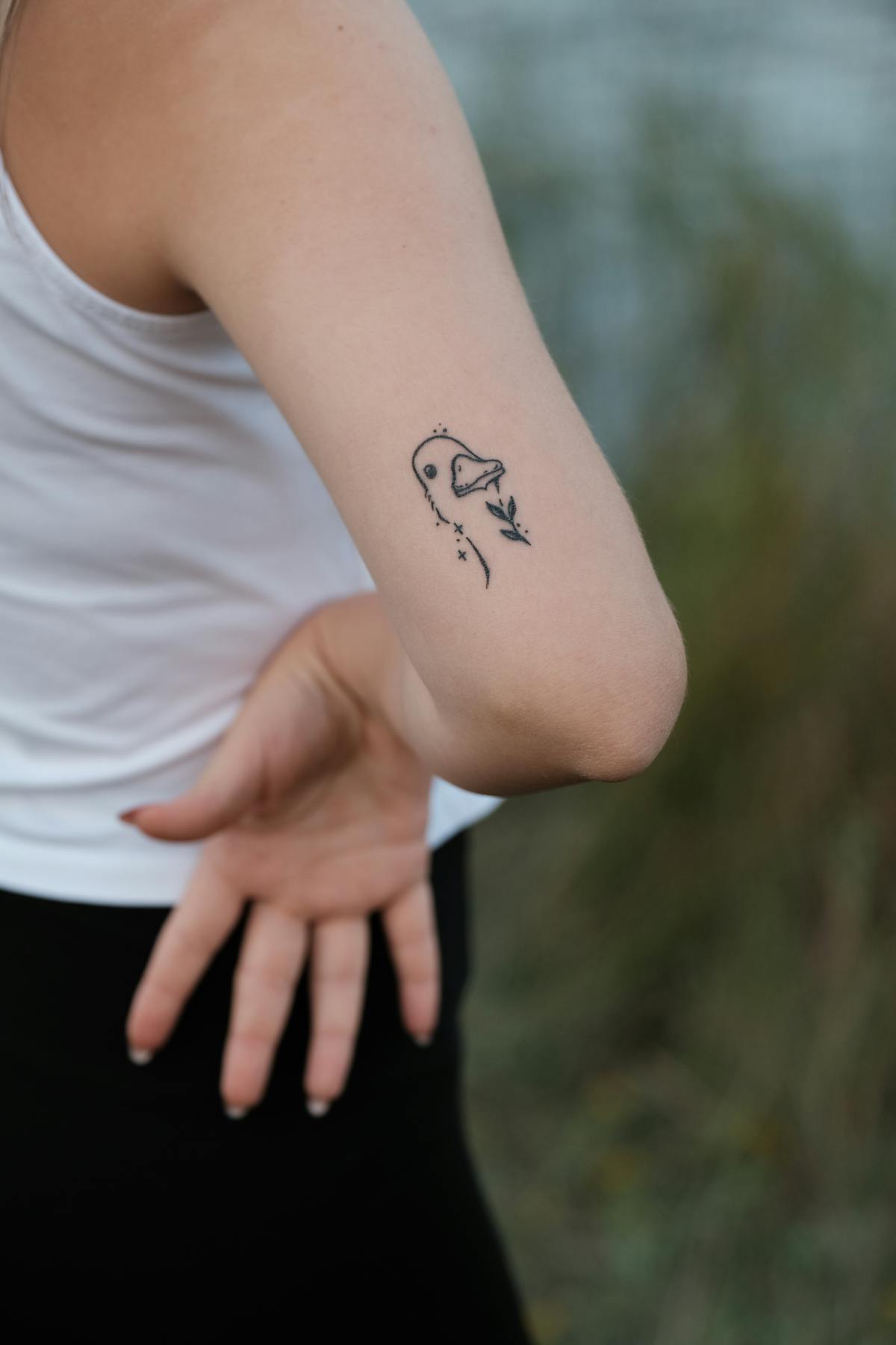 Micro detail bird tattoo on the upper arm, fineline.