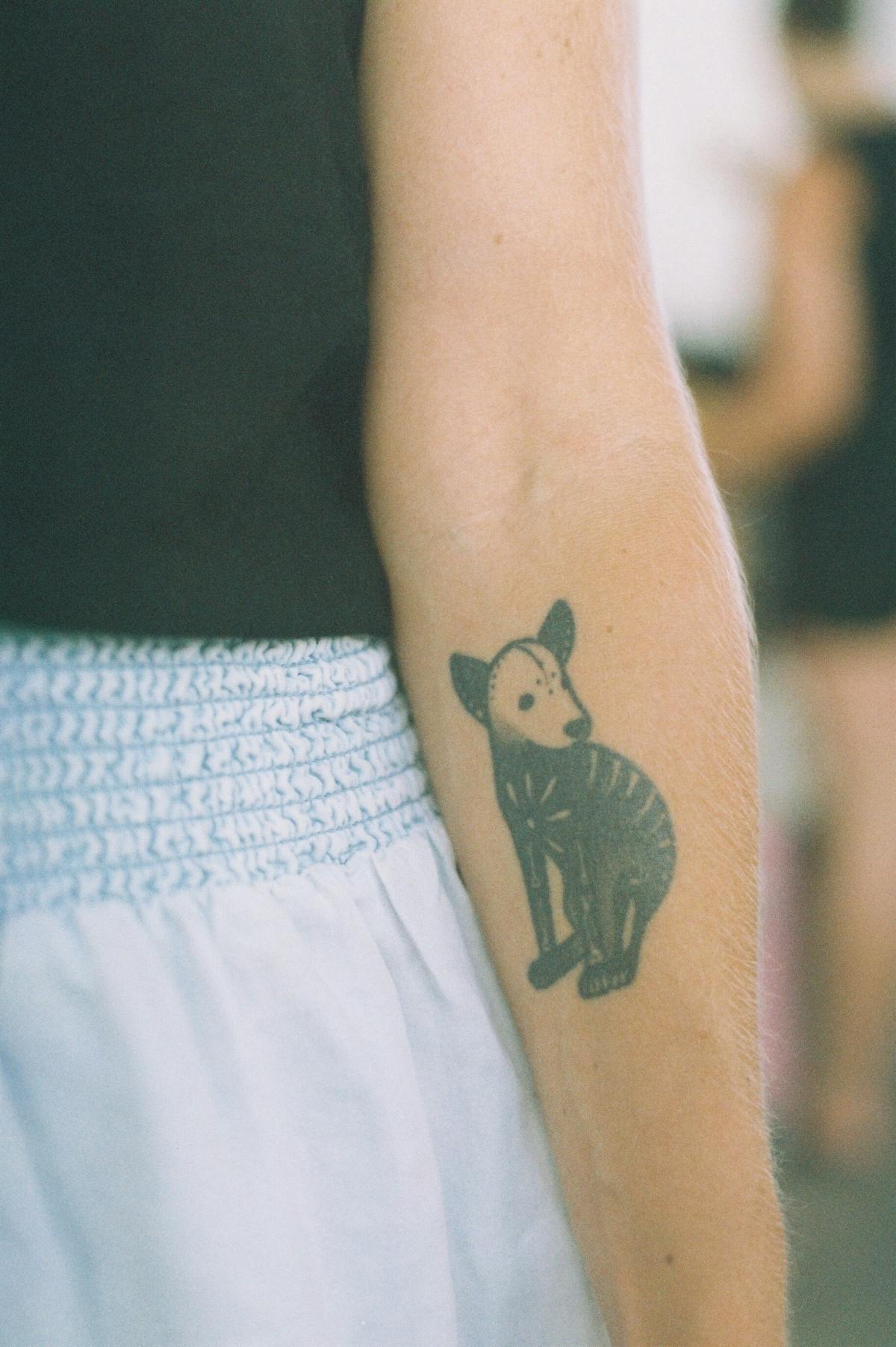 Folk-style animal tattoo on the forearm, blackwork.